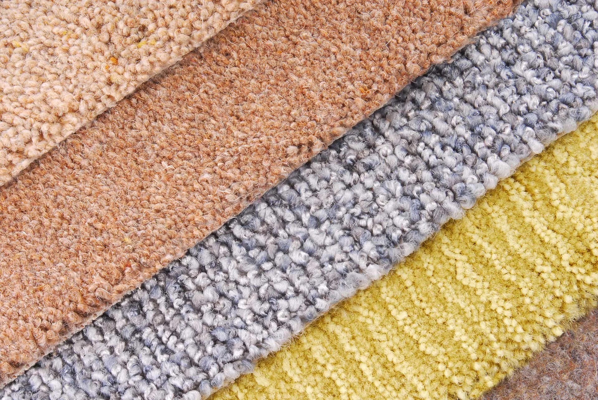 Loop-pile carpet fiber samples in beige, brown, grey, and mustard tones